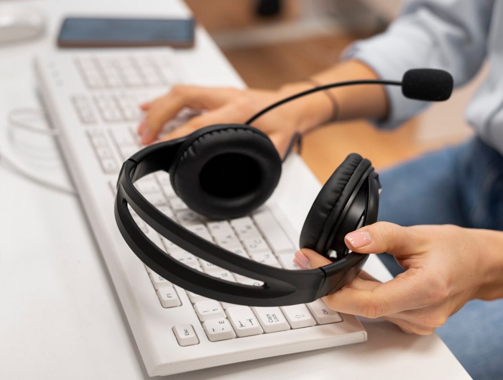 woman-working-call-center-holding-pair-headphones_23-2149256146